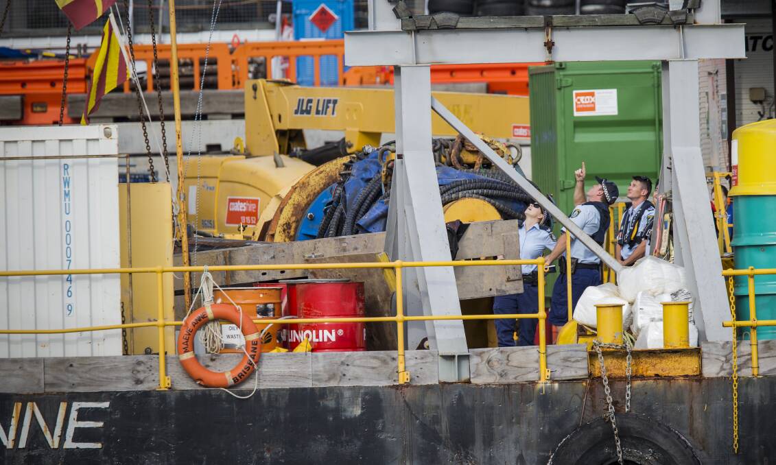 Police point to a crane on a barge where a man died on Wednesday. Photo: David Porter