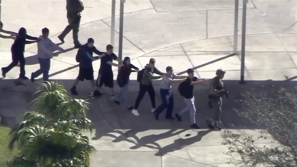 Students leave the school which was placed on a "code red" lockdown. Picture: AP