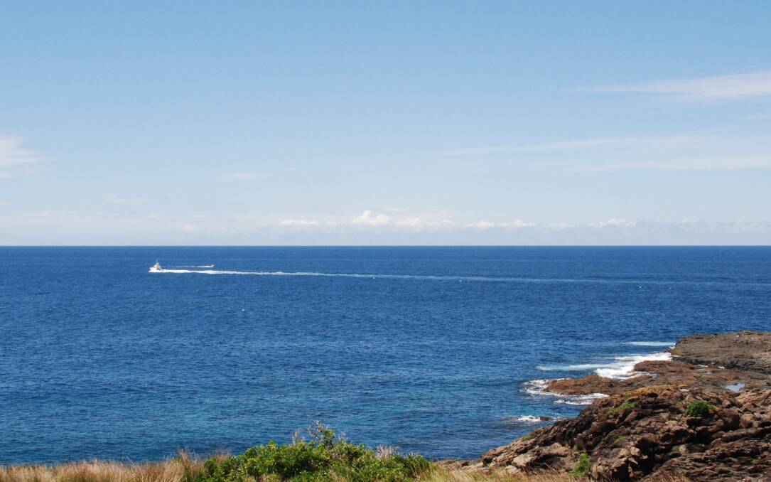 A water police boat heads north from Kiama Lighthouse, Tuesday afternoon. Picture: ANGELA THOMPSON