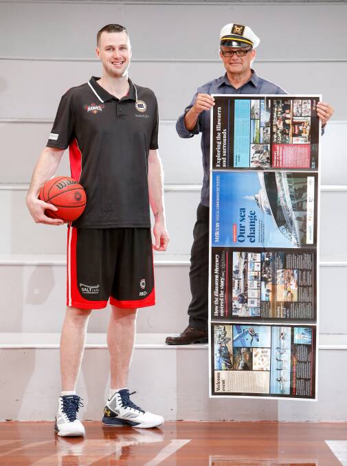 TALL AND SHORT OF IT: Illawarra Hawks centre AJ Ogilvy checking out the size of the special feature in Saturday's edition of the Illawarra Mercury with Cr or "Captain" Leigh Colacino. Picture: Adam McLean.