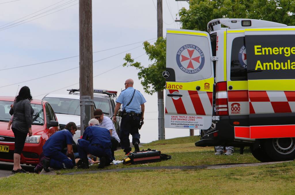 DARTED OUT: Paramedics on Dempster Street surround the injured five-year-old, who cried loudly throughout her ordeal. Picture: Adam McLean.