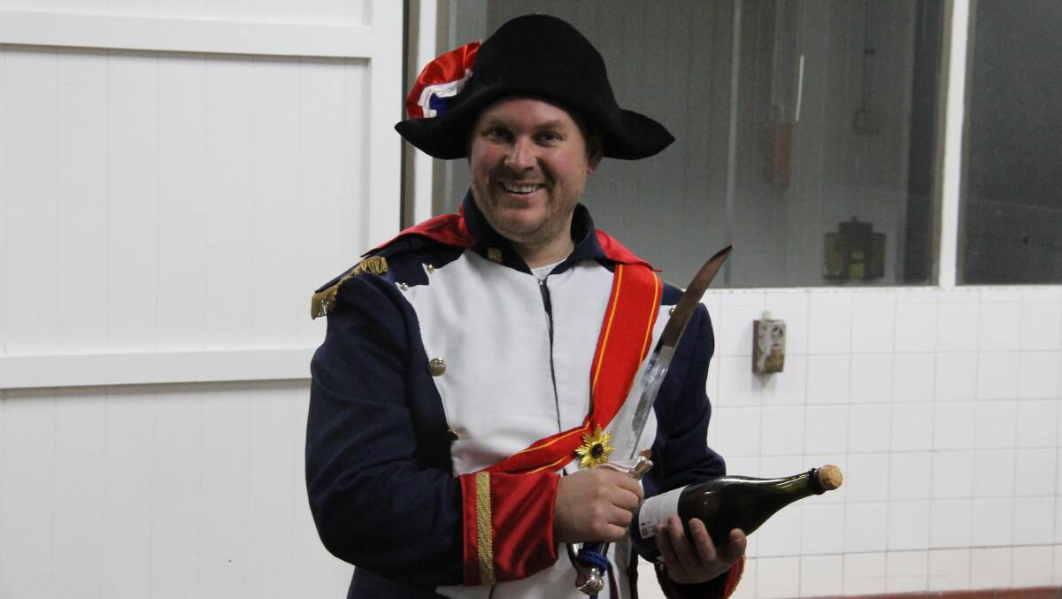 Danial Ahchow … dressing up as a Napoleonic soldier to open a bottle of sparkling the traditional way.