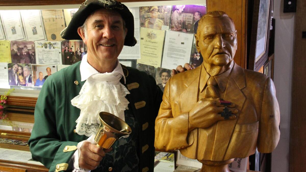 Maryborough Town Crier Ken Ashford with a statue of Keith Payne VC … the city has a proud military tradition. 