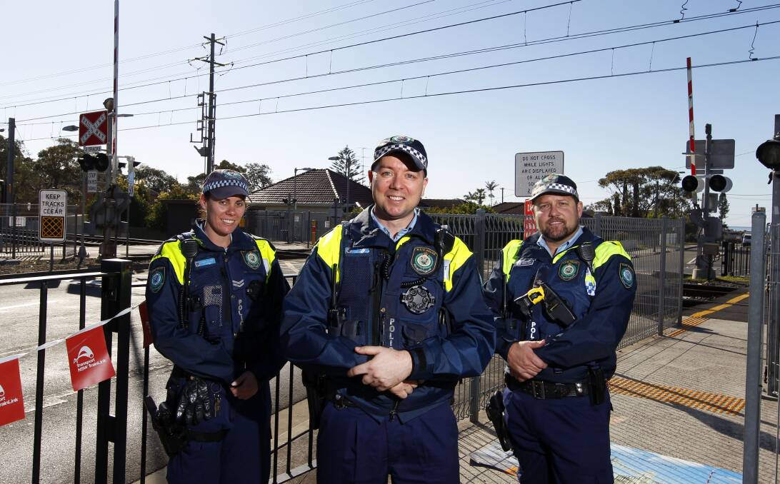 Don't cross: Police Transport Command members Constable Kim Smith, Senior Constable David Bott and Detective Sergeant Darryl Smith at Woonona train station. Picture: Anna Warr