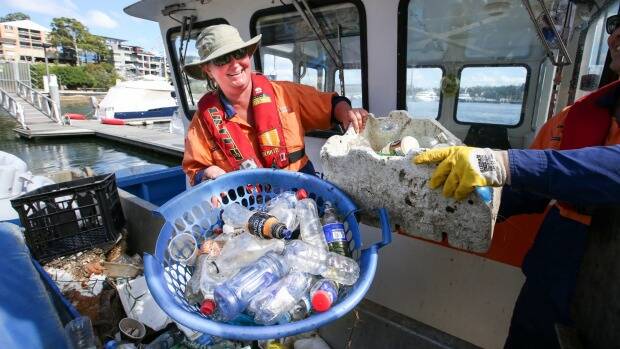 Clean Up Australia Day volunteers battle the bottle scourge in Sydney's waterways in March this year. Photo: Peter Rae