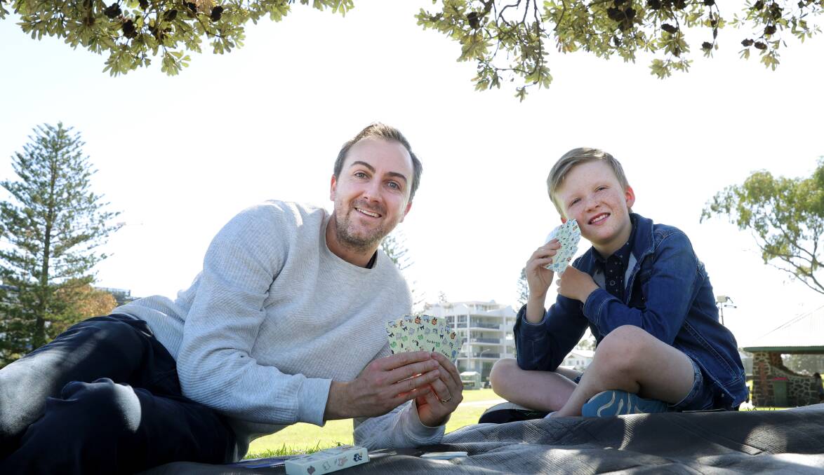 Evan Turner and his son Levi Turner playing their card game Go Bum in Lang Park, Wollongong. Picture by Sylvia Liber