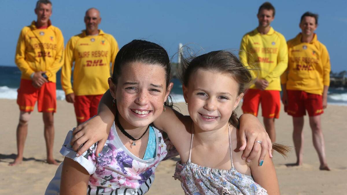 Laiken Turner, 11, and Summah Arnold, 7, with (back, from left) Damian Evans, Duane Arnold, James Brighton and David Mewett. All are from the North Wollongong Surf Life Saving Club and played a role in the December 18 ocean rescue. Picture: Robert Peet