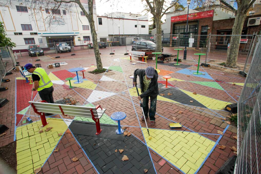 Splash of colour: Workers install the new pop-up seating project in Wollongong's arts precinct, designed to add life and colour to the culutral hub. Picture: Adam McLean.