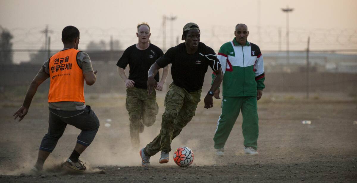Kicking goals: Private Bukasa starred in an Iraqi-Australian soccer match and has relished the chance to bond with other troops through the game he loves.