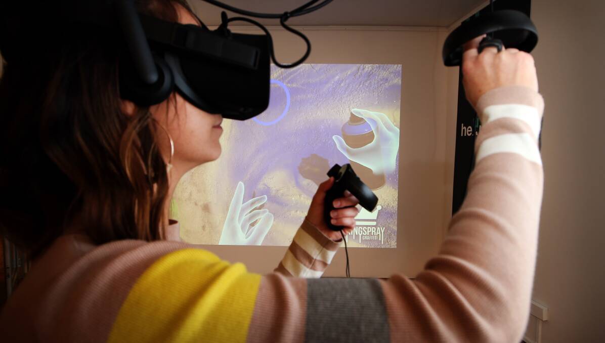 Hands on: Illawarra artist Claire Foxton tries out a virtual reality graffiti simulator at Heuristic, Wollongong Art Gallery. Picture: Sylvia Liber