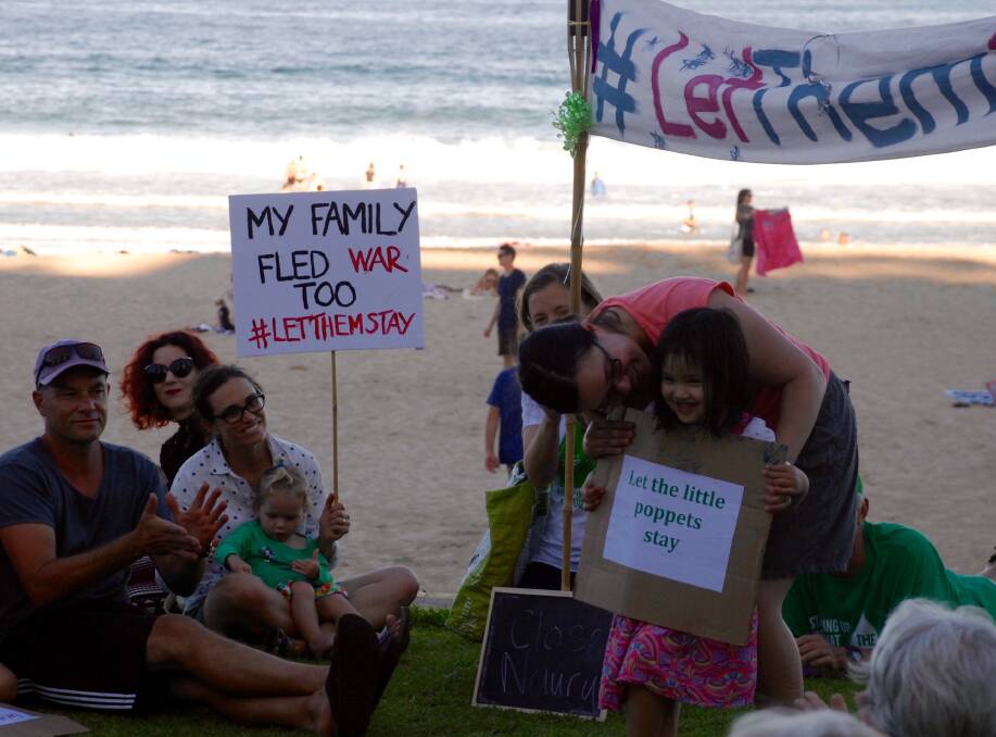 Let them stay: Four-year-old Ellie Yang shares her message with protesters at North Wollongong beach on Monday evening. Picture: Kate McIlwain