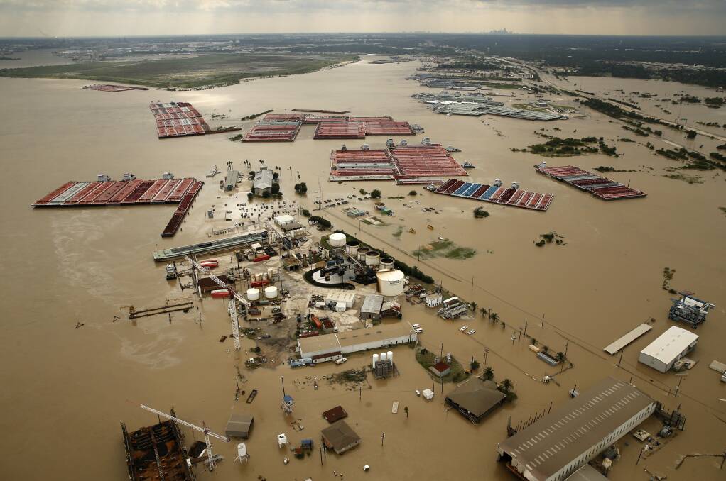 HAVOC: Barges are secured by tugboats in the flood-swollen Burnet Bay along the Houston Ship Channel in the southeast of the US. Picture: AP