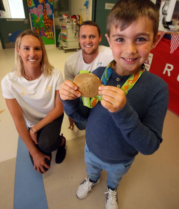 AWESOME: Before starting five hours of allergy tests at Wollongong Hospital, 7-year-old Jack Broadhead's attention was caught by Olympians Emma and David McKeon. Picture: Robert Peet