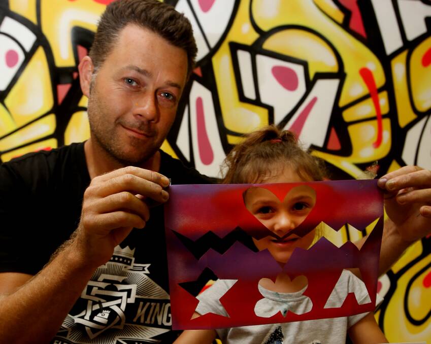 GRAFFITI ARTIST: Tim Phibs during a workshop at Wollongong Central, showing kids - like Amani Spicer from Bulli - positive forms of 'street art'. Picture: Robert Peet