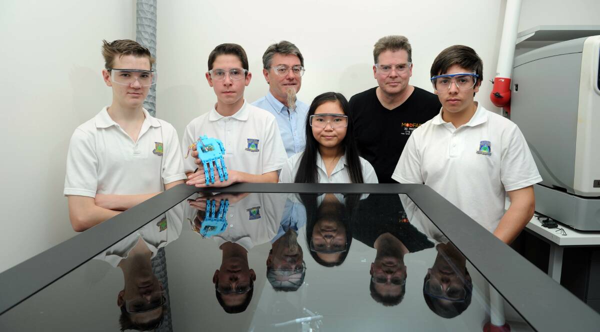 Hands down winners: Figtree High students Chad Dewhurst, James Kuzman, Tiffanie Doan, Chris Kiotis with their 3D printed bionic hand. Picture: SIMON BULLARD