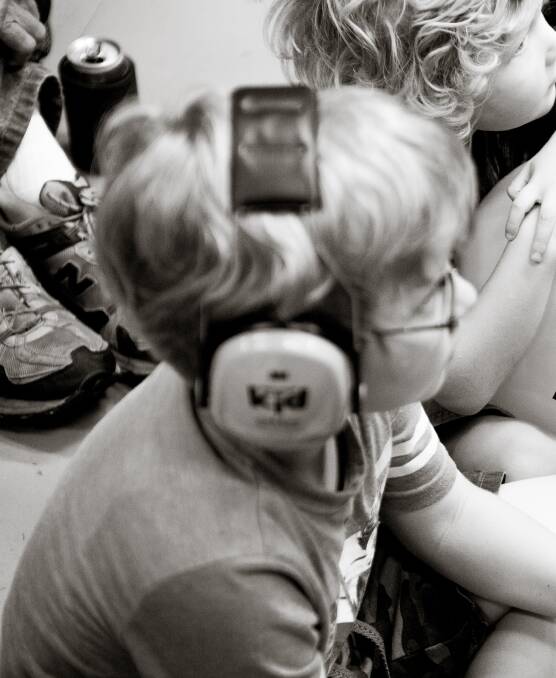 CAPTURING THE MOMENT: Children watching the Dune Rats perform for Record Store Day. Picture: Chris Frape
