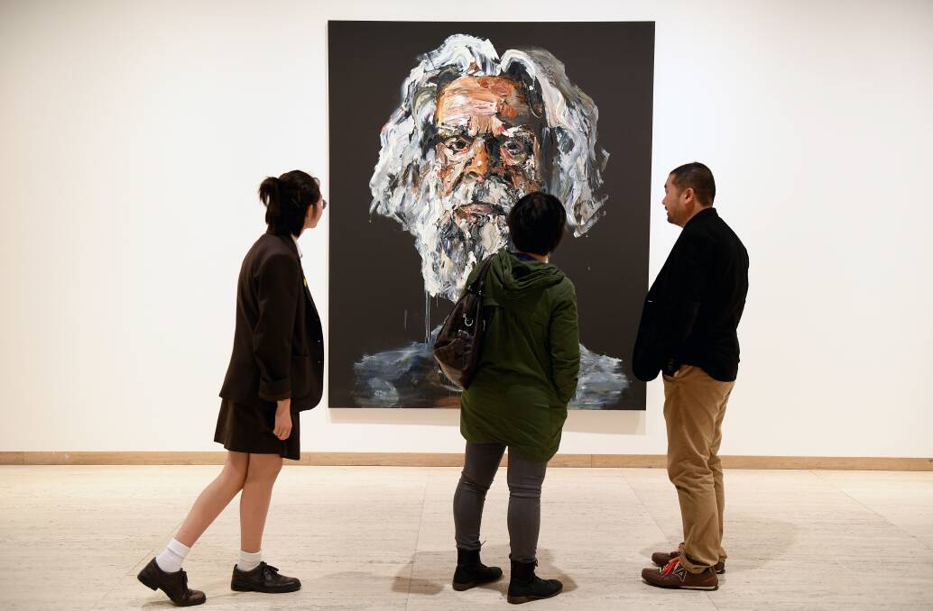 Visitors inspect entries to the 2017 Archibald Prize, including JC by Anh Do. Picture: AAP/Dan Himbrechts