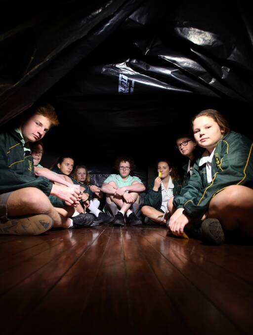CHANGING THE FUTURE: Woonona High School students in a mock "leaky boat", learning hands-on what it would be like to be a refugee. Picture: Sylvia Liber