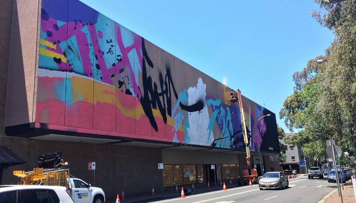 RAINBOW: Artist Ian McCallum continues adding colour to his mural on Burelli Street on Friday. Picture: Fairfax