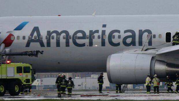 Chicago firefighters investigate the fire damaged American Airlines jet. Photo: Antonio Perez