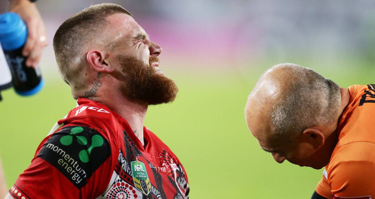 OUCH: Josh Dugan winces in pain as Dragons medical staff attend to his injured elbow in the Dragons 34-24 loss to South Sydney on Thursday night. Picture: Getty Images