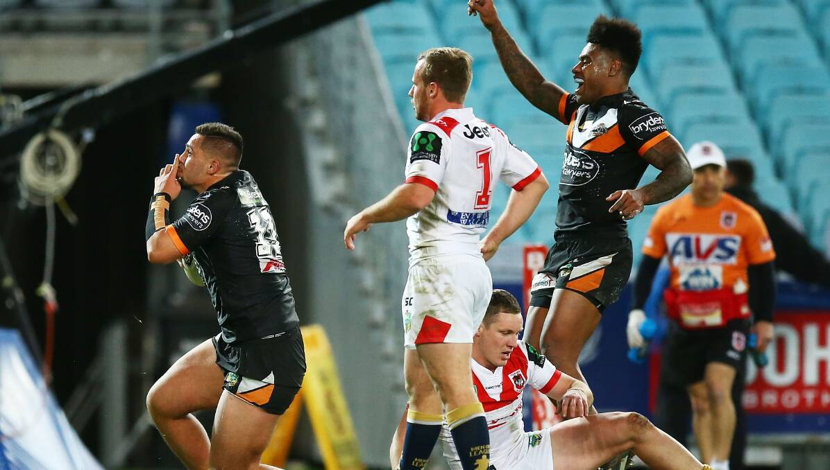NEW LOW: Tigers players celebrate Josh Aloiai's second half try in their 25-12 win over the Dragons on Sunday. Picture: Getty Images