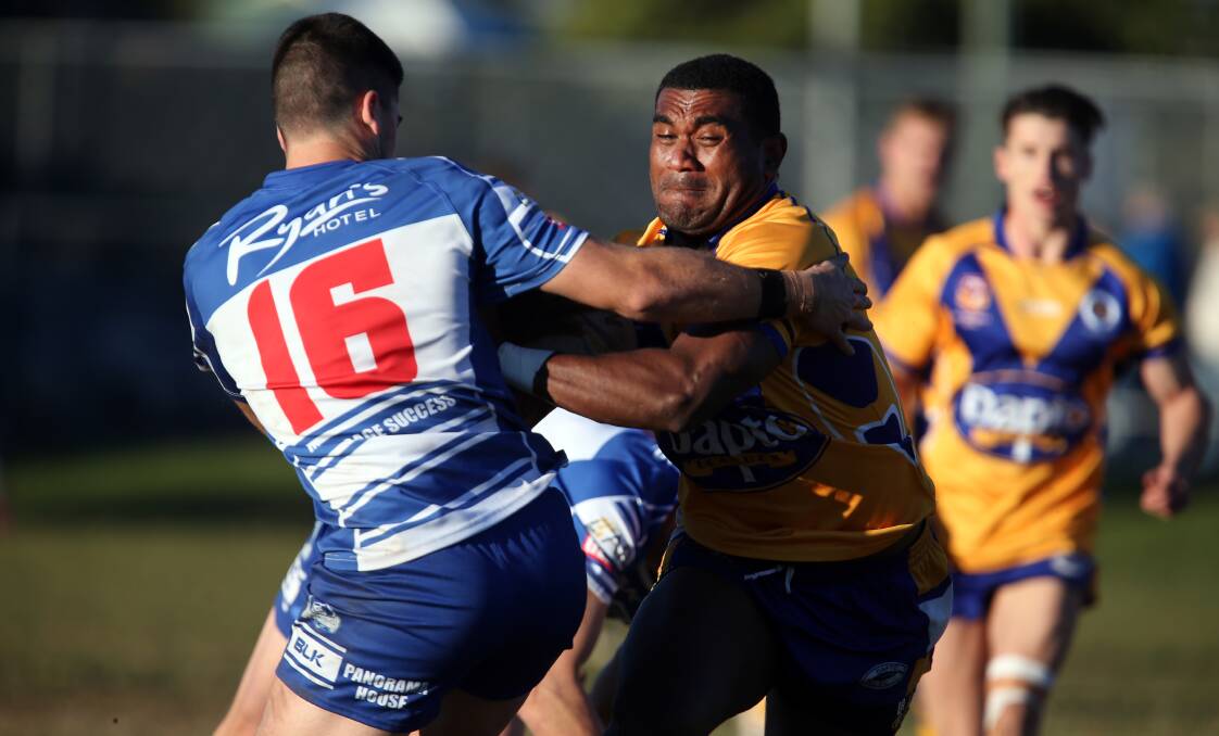 ONSLAUGHT: Dapto winger Ron Beauserau wrestles with the Thirroul defence in the Canaries 57-0 win on Saturday. Picture: Sylvia Liber