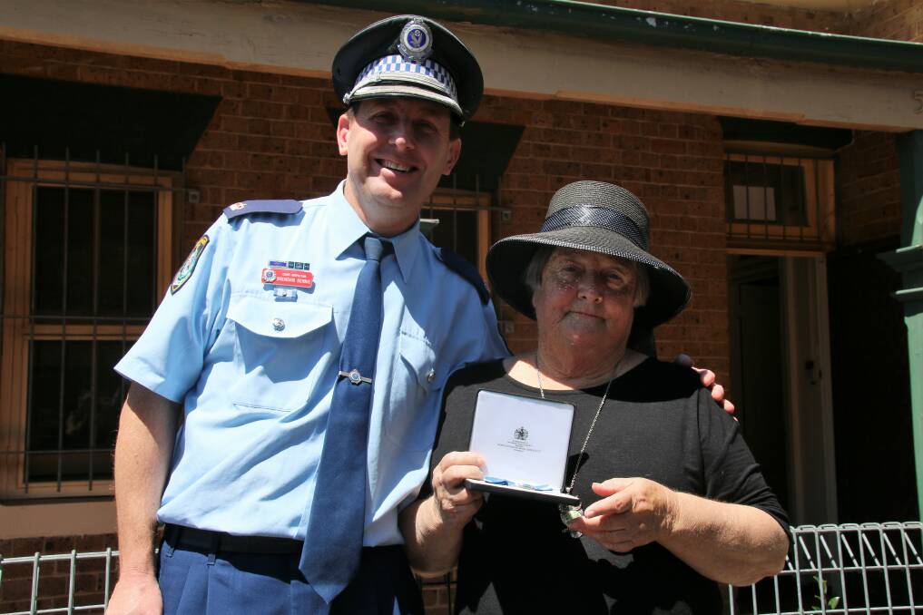Hume LAC Police officers and Assistant Commissioner Gary Worboys present Queen's Gallantry Medal recipient Margaret Warby with a replacement medal after hers was stolen in a break in. Photos: Victoria Lee
