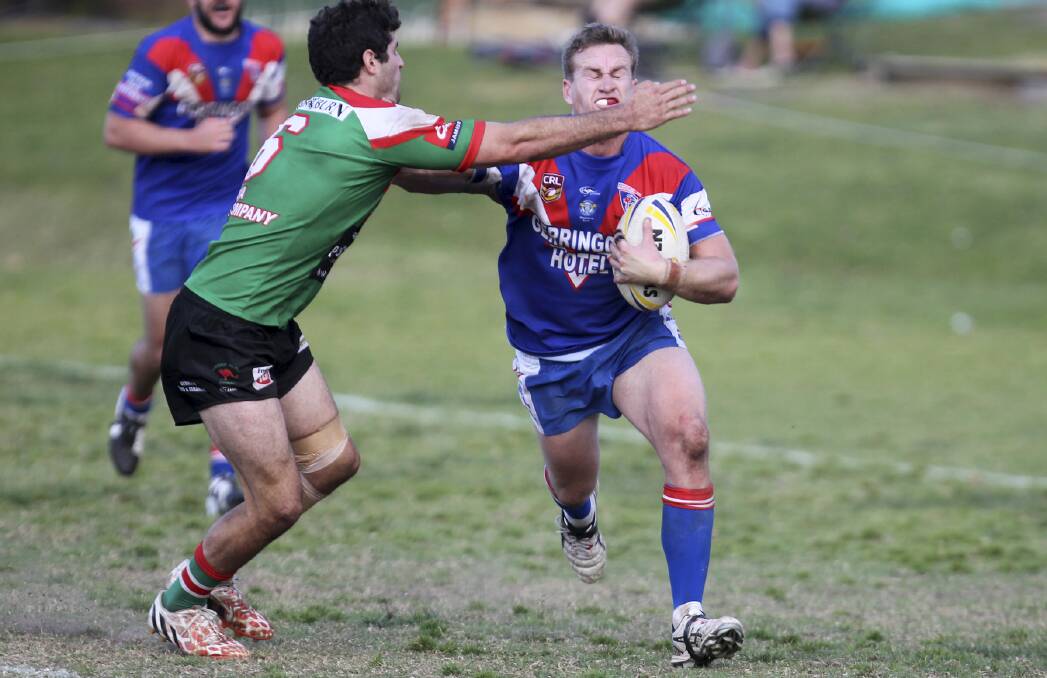 RECORD BREAKER: Joel Roberts is attempted to be tackled by Jamberoo's Mark Asquith. He is now Group Seven's leading point scorer. 