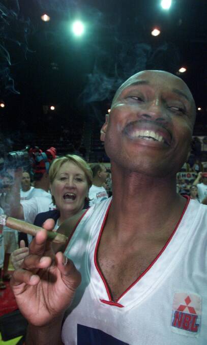 Celebration: Damon Lowery smokes a cigar after Wollongong won the NBL title in game three in Townsville in April 2001. Picture: ROBERT PEET