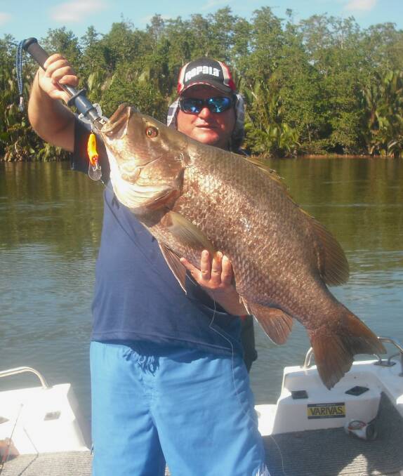 Reeled in: Tony Williams with an enormous PNG black bass during a recent trip.