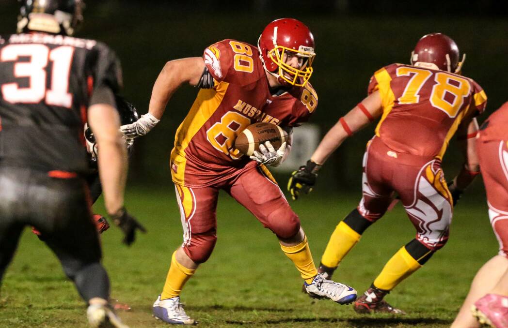 On the run: Wollongong Mustangs player Kenny Ivers makes some rushing yards during a game last season. The team plays at Corrimal on Saturday. 