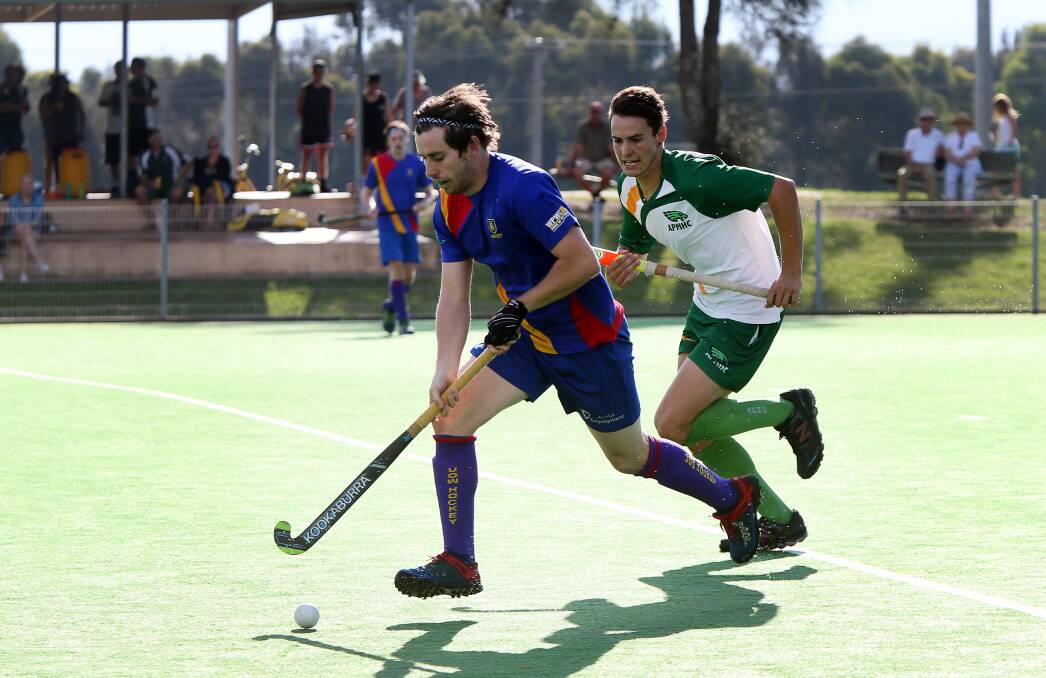 Chase: University's Nick Jennings tries to evade Albion Park rival Jack Hayes in their Illawarra hockey showdown. Picture: Sylvia Liber