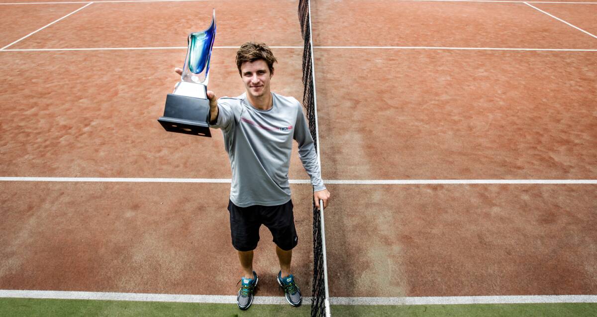 The spoils: Ben Mitchell holds the Wollongong International trophy after beating Germany's Sebastian Fanselow in straight sets on Sunday. Picture: Georgia Matts