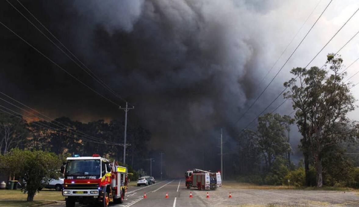 FIRESTORM: With roads blocked, fire crews get ready to protect property as one of two fires bears down on the Coalfields towns of Kurri Kurri and Heddon Greta. Picture: Michael John Fisher