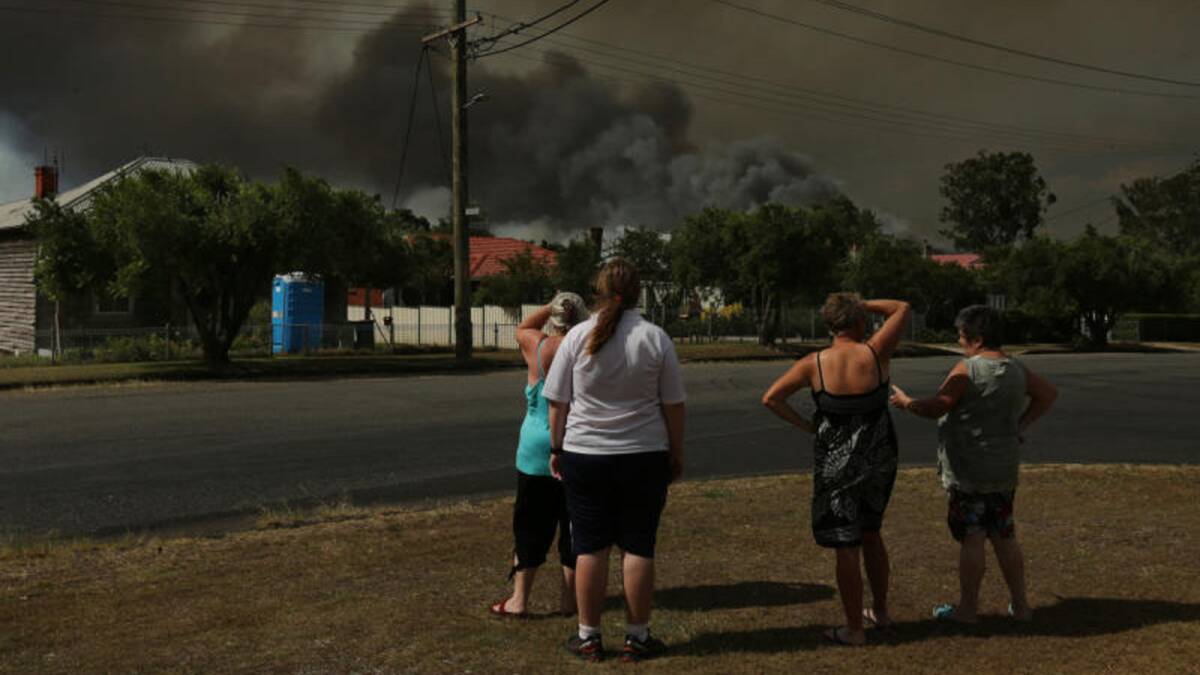 WORRY: Families can do nothing but look on as huge plumes of smoke rise from the deliberately-lit fire to fill the sky. Picture: Simone De Peak