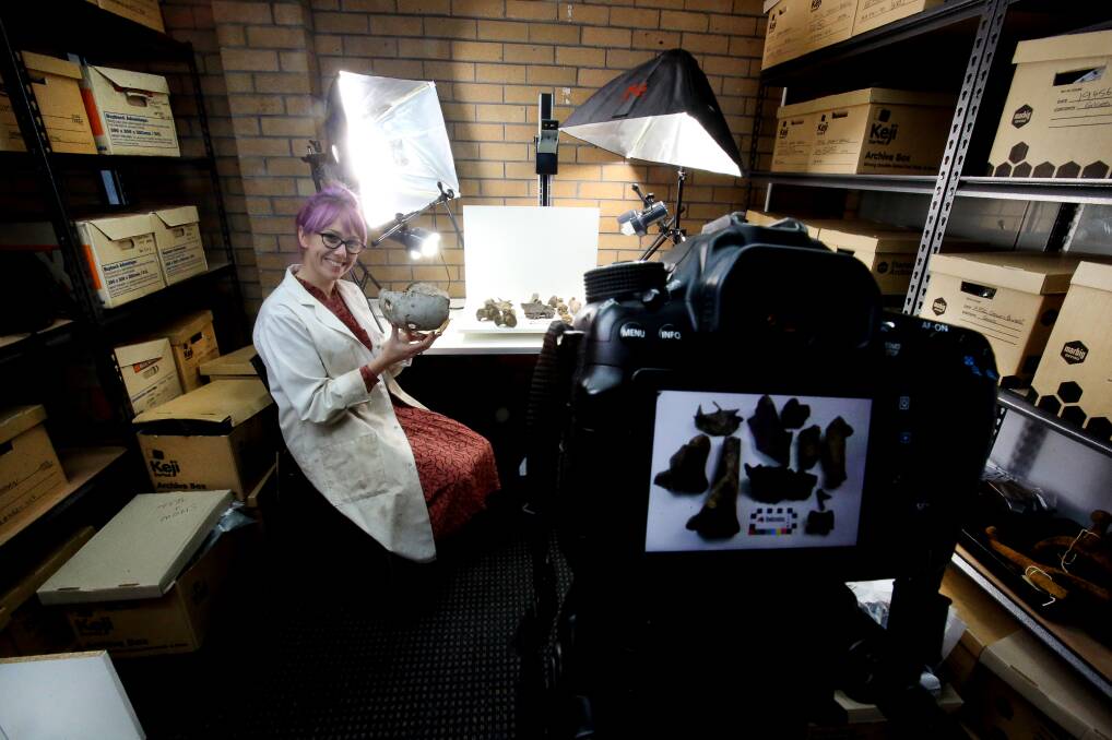 Lian Flannery with boxes of artefacts unearthed at the former Dwyer's site and the former Oxford tavern line the walls of Biosis' Wollongong office. 