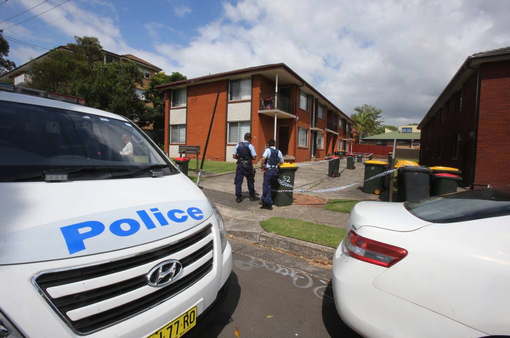 Police officers keep watch over the scene of a violent scuffle that spilled onto Kembla Street about 8am Tuesday. Picture: Robert Peet