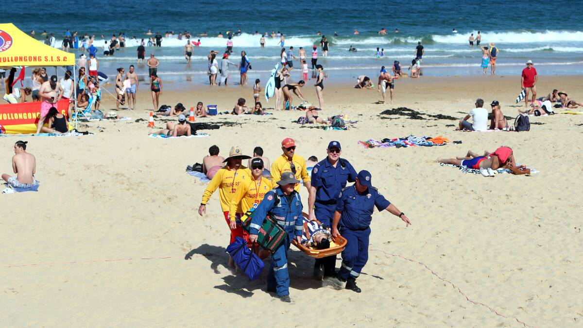 STRETCHER: The injured man is carried from the sand. 