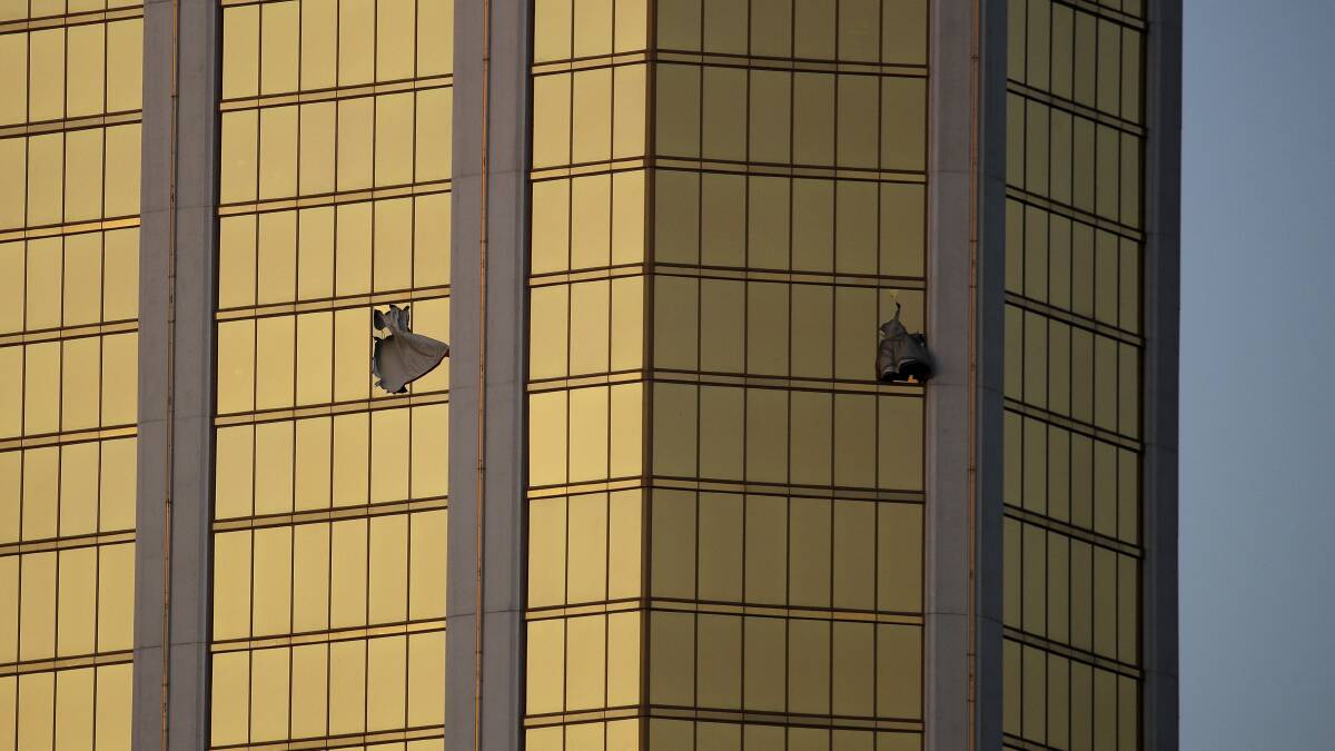 Drapes billow out of broken windows at the Mandalay Bay resort and casino. Authorities say Stephen Craig Paddock broke the windows and began firing with a cache of weapons, killing dozens and injuring hundreds. Photo: John Locher, AP