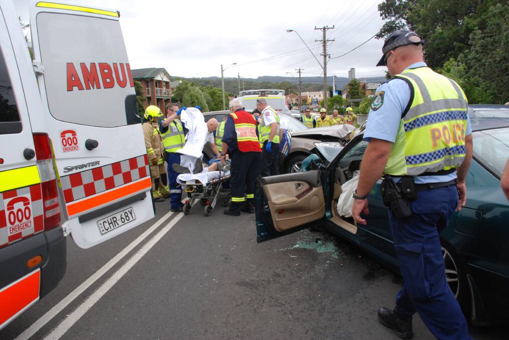 An elderly man is helped from his wrecked car and into a waiting ambulance. Picture: Angela Thompson