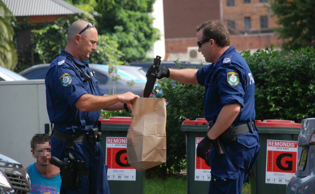 A man is arrested on Smith Street after police seize items from his car. Pictures: Angela Thompson