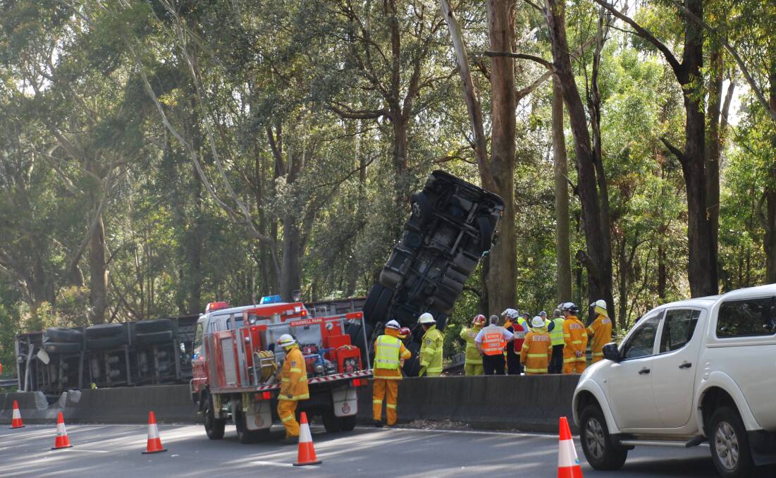 Emergency services converge on the motorway as traffic banks up behind an overturned semitrailer. Picture: Angela Thompson
