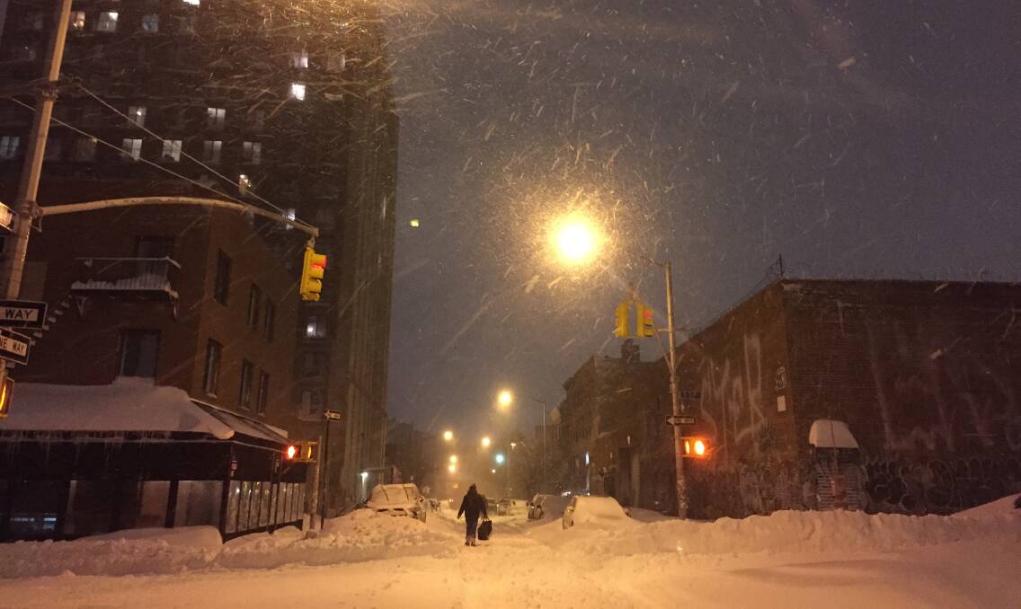 A lone food delivery worker braves the night storm. Picture: Renee Bartsch