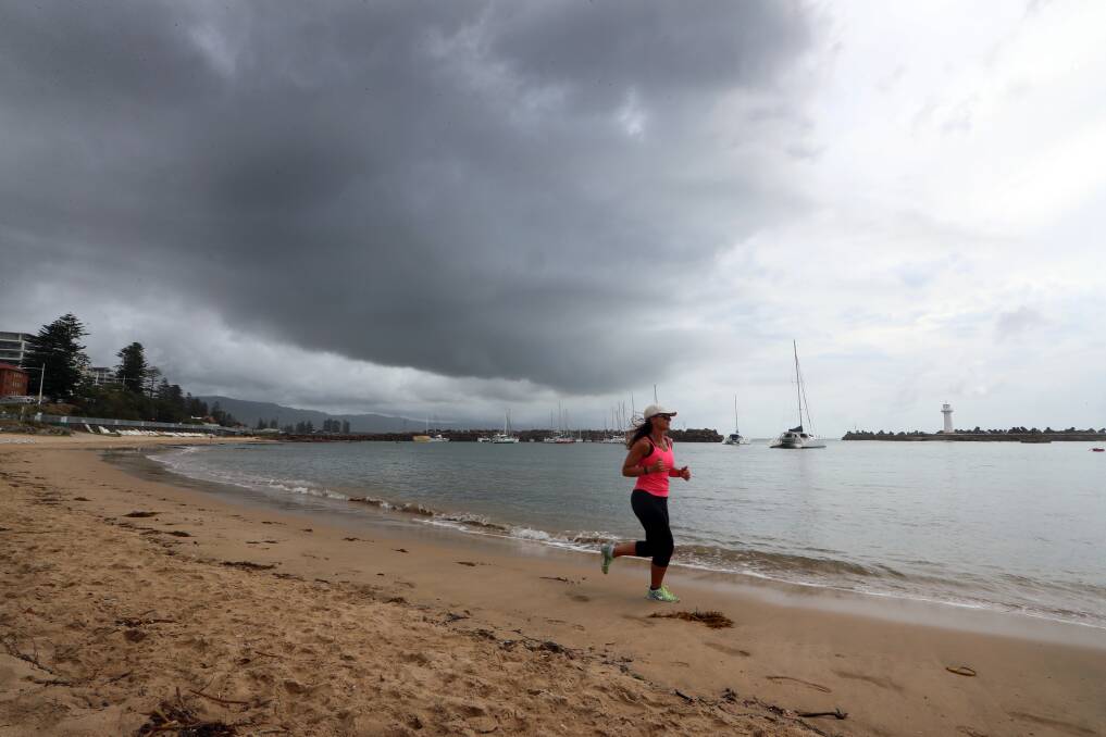 Gloria Chicia hits the sand at Wollongong Harbour as the storm moves in, late Monday morning. Picture: Sylvia Liber 