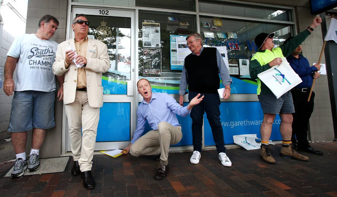 Councillor Andrew Sloan deposits a petition under the door of Gareth Ward's Terralong Street office. Picture: Sylvia Liber