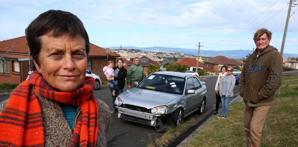 OVER IT: Kim Williams and fellow Storey Street residents inspect the car, which has been parked in the same place since April. Picture: Robert Peet