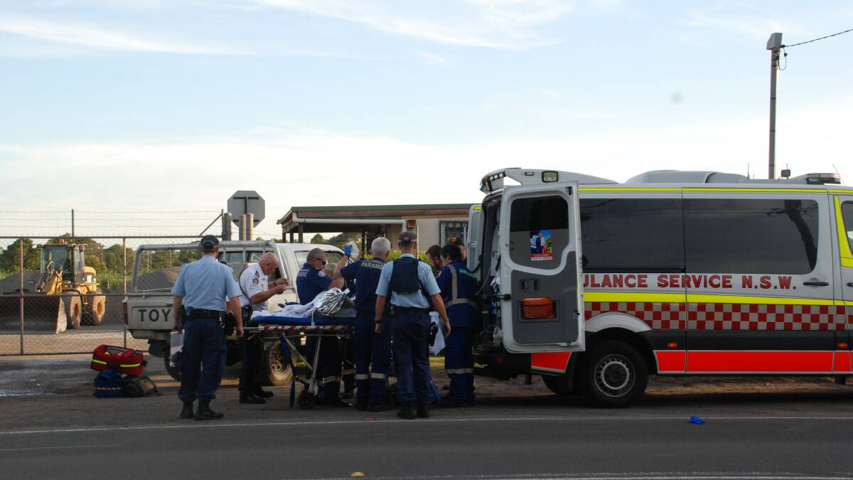 Emergency services treat the victim of a car fire on West Dapto Road. Picture: Angela Thompson