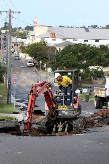 REPAIRS: A Sydney Water worker operates machinery at the site of the burst main, Wednesday morning. Picture: Sylvia Liber