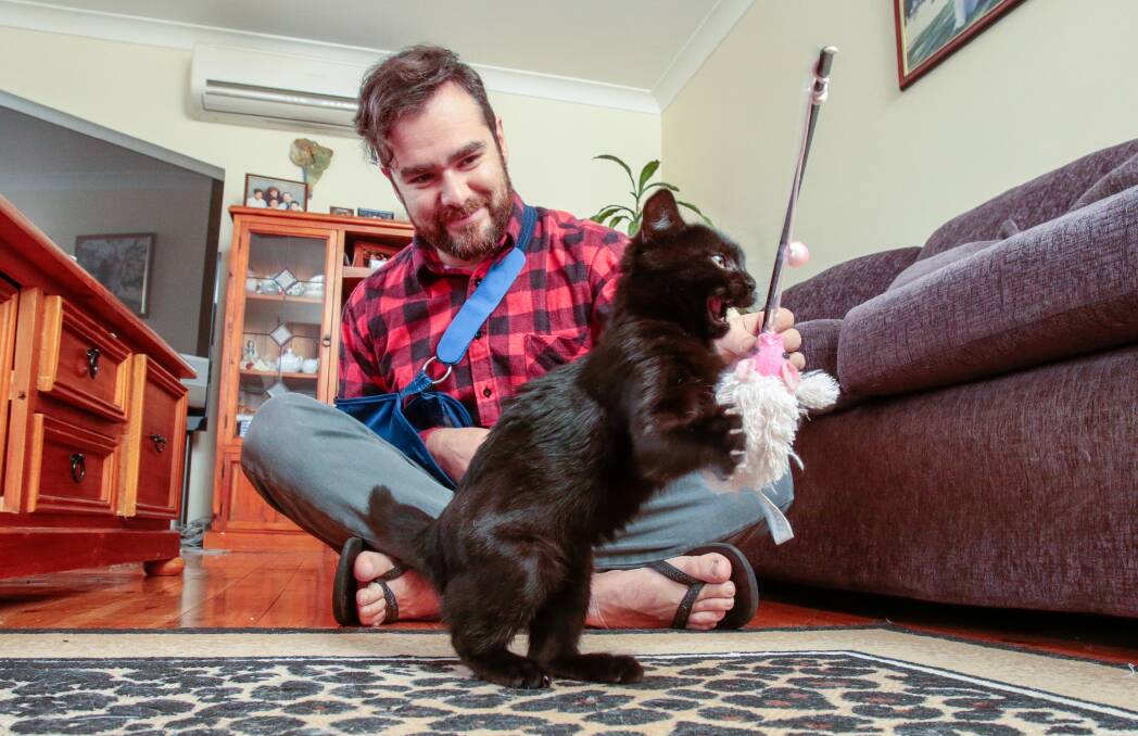 Furever home: Mauricio Quijano puts Friday through her paces at the kitten's new home. Picture: Adam McLean